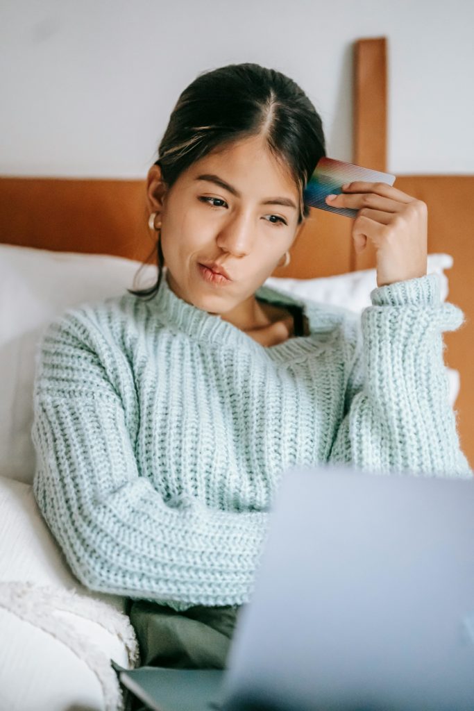 Photo by Liza Summer: https://www.pexels.com/photo/pensive-ethnic-shopper-with-debit-card-and-laptop-on-bed-6347709/